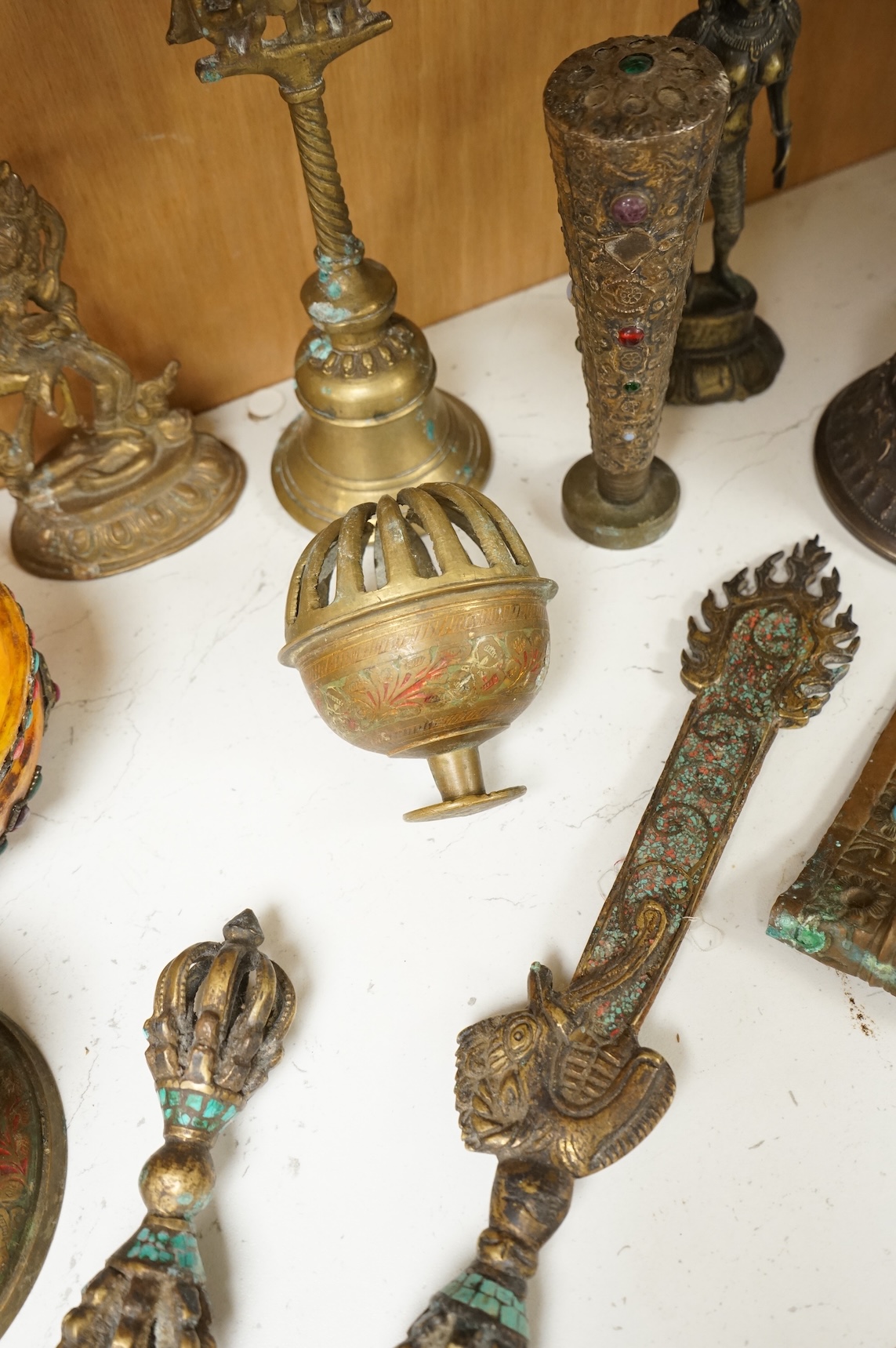 A group of Tibetan brass and mixed metal artefacts to include a brass vase with cabochon inset stones and figures of deities, largest 22cm high